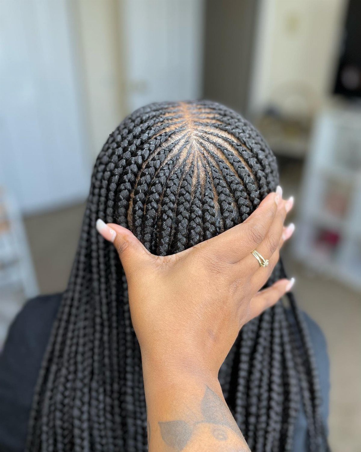 5 Middle Part Tribal Braids with Beads, Curls and More 5 Black tribal braids with a middle part and geometric scalp patterns on a person