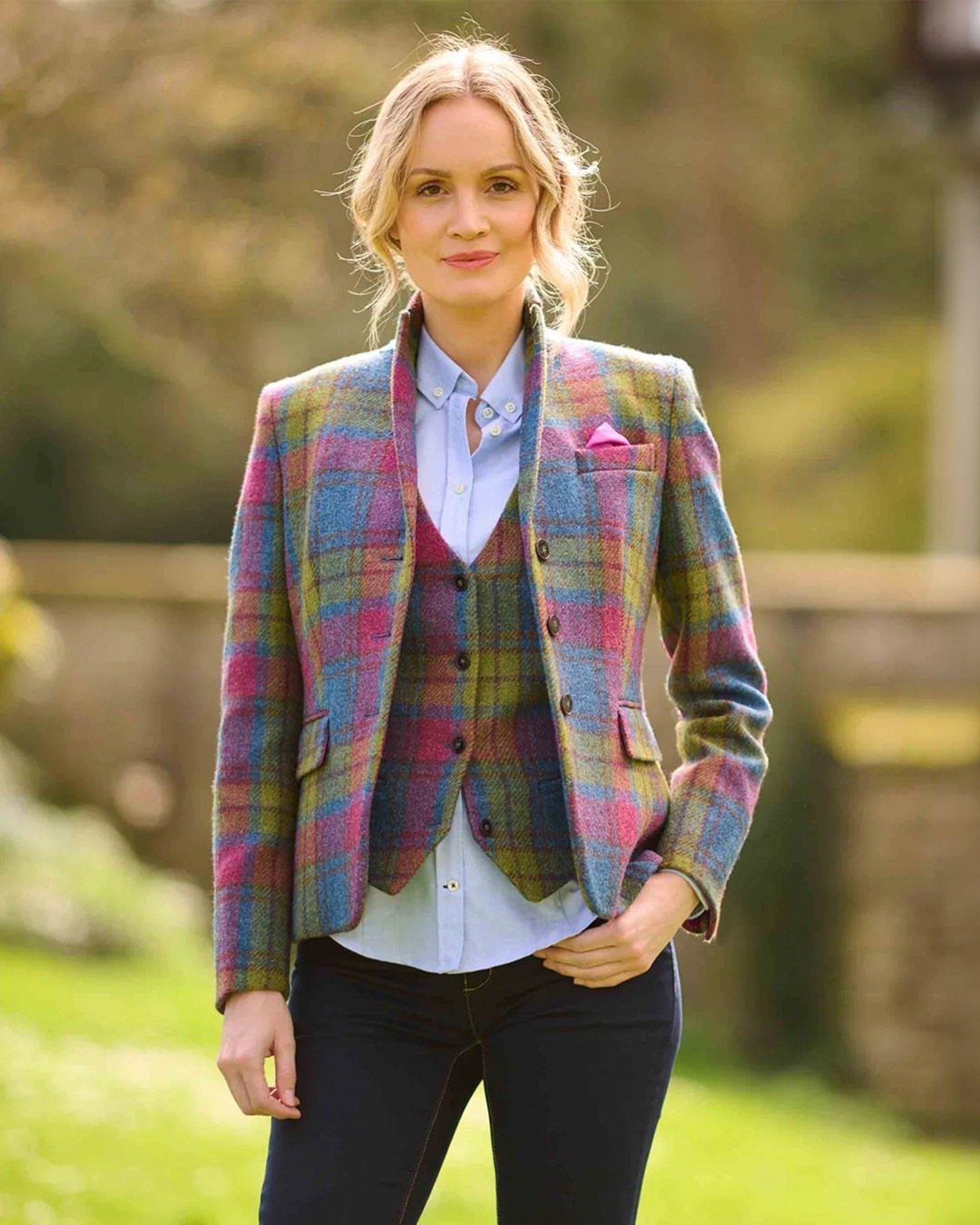 Woman wearing a colorful plaid tweed blazer and matching waistcoat in a garden