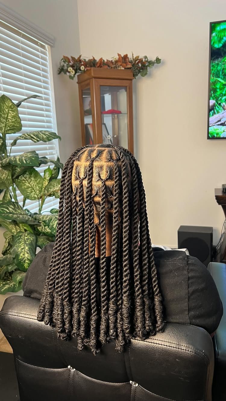 Long black rope twists in square sections seen from the back of a person.