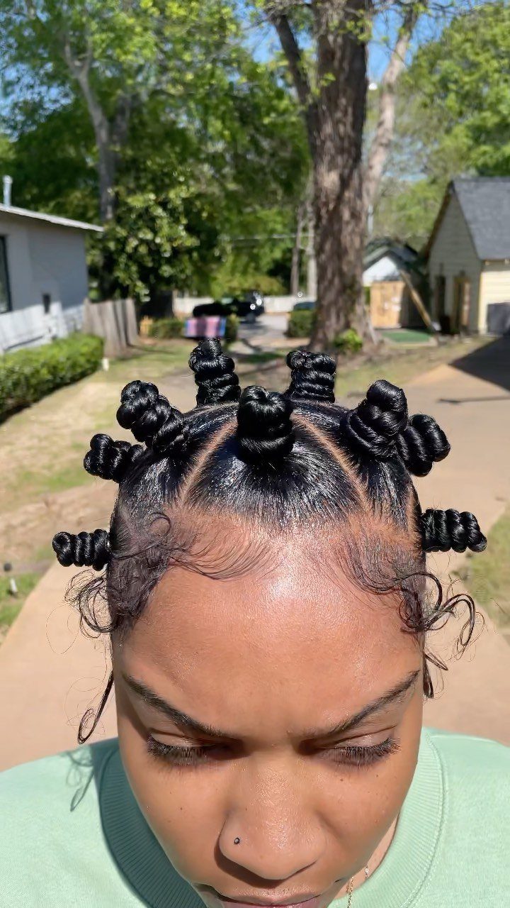 Natural Long Hairstyles: 10 Ideas, From Bantu Knots to Waves 9 Woman with black hair styled in coiled Bantu knots on her head.