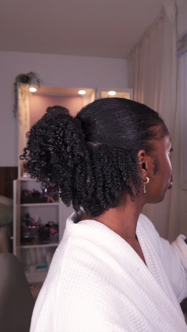 Natural Long Hairstyles: 10 Ideas, From Bantu Knots to Waves 1 Woman with curly dark hair styled in a half-up, half-down high ponytail.
