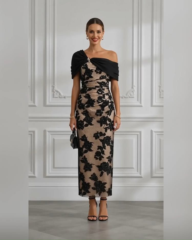 Woman in a black floral lace overlay midi dress with off-the-shoulder neckline.