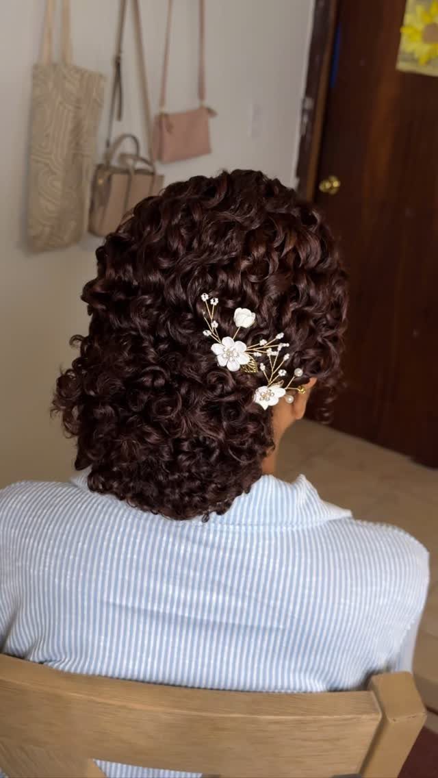11 Peinado Pelo Rizado Ideas for Every Curl Type 5 Dark curly hair with a white floral accessory seen from the back