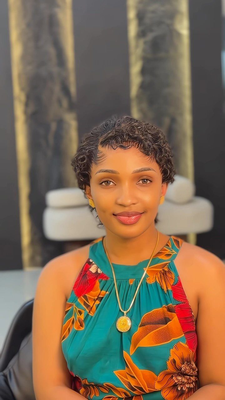 11 Peinado Pelo Rizado Ideas for Every Curl Type 6 Woman with short dark curly hair wearing a teal floral dress and gold necklace.