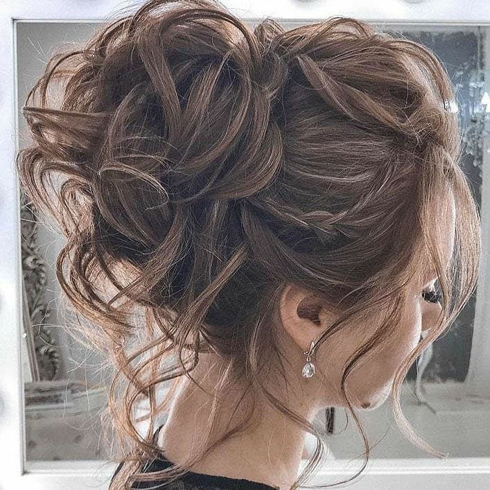 11 Peinado Pelo Rizado Ideas for Every Curl Type 11 Brown curly hair styled in a voluminous messy bun with loose face-framing strands.