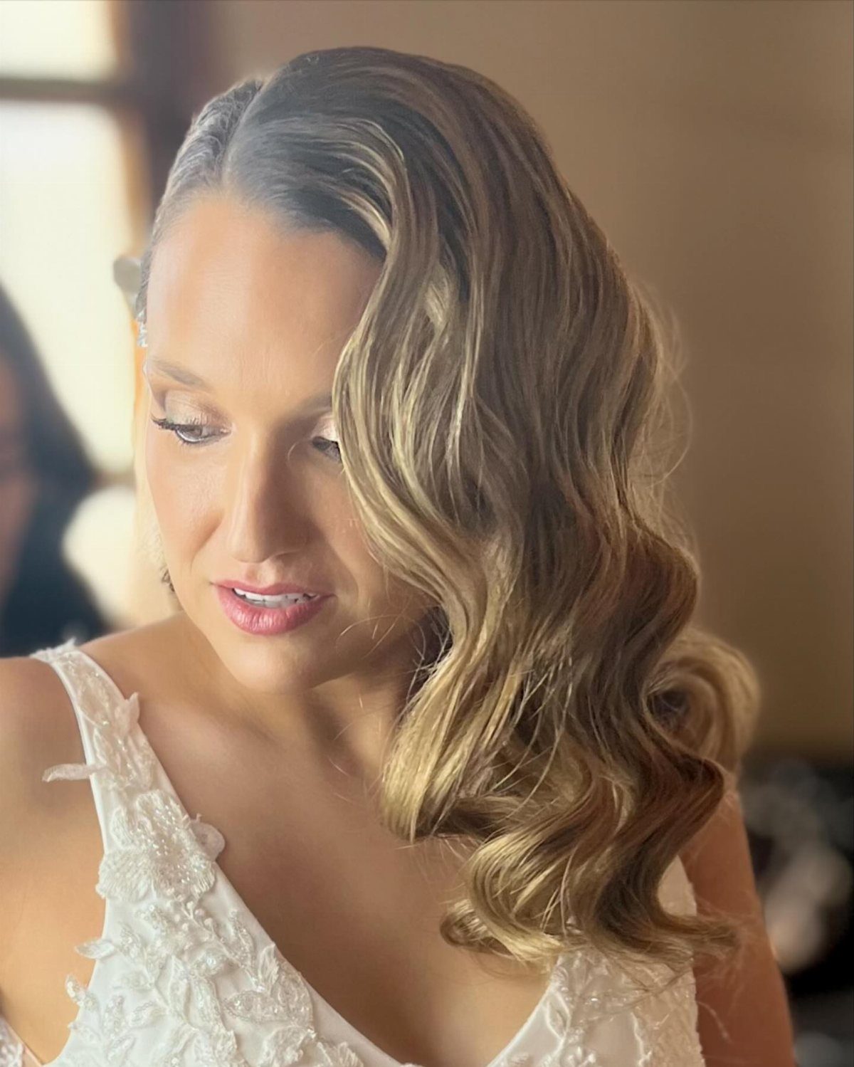 11 Peinado Pelo Rizado Ideas for Every Curl Type 9 Woman with blonde wavy hair styled to one side wearing a white lace dress
