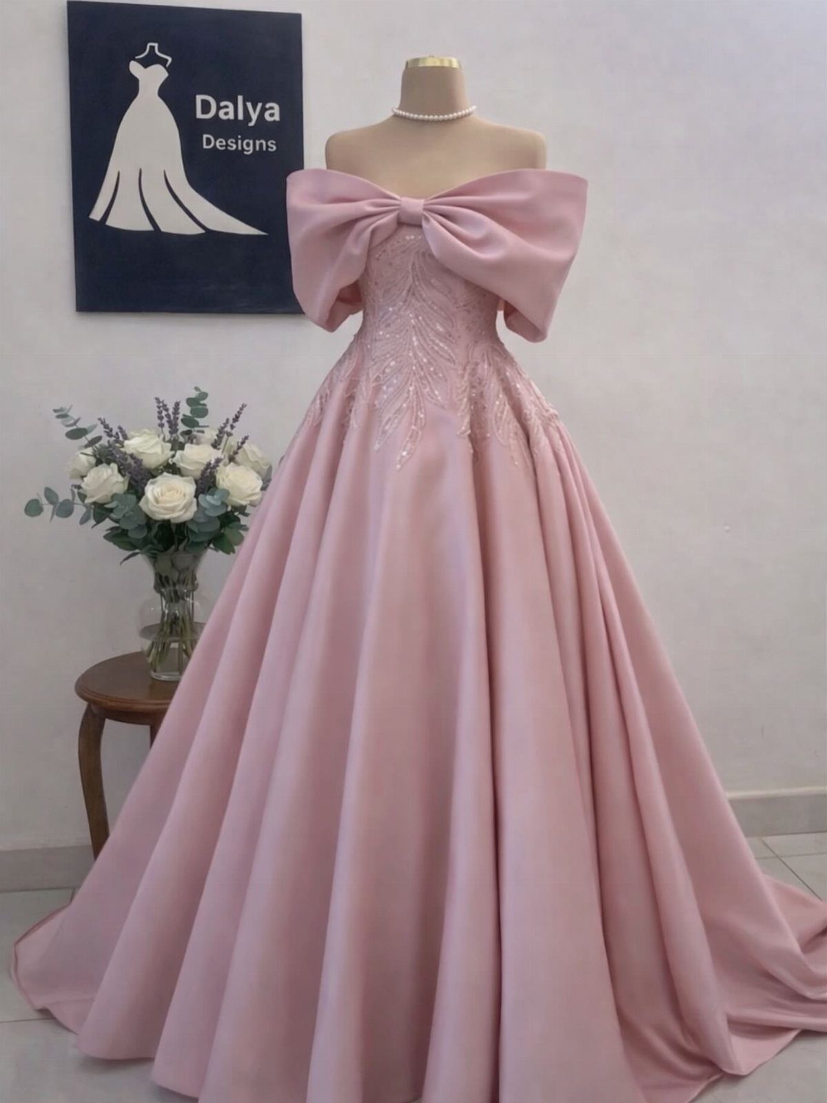 Pink Ballgown Wedding Dress: 8 Ideas with Bows and Feathers 2 Pink satin ballgown on a mannequin featuring a large statement bow at the neckline.