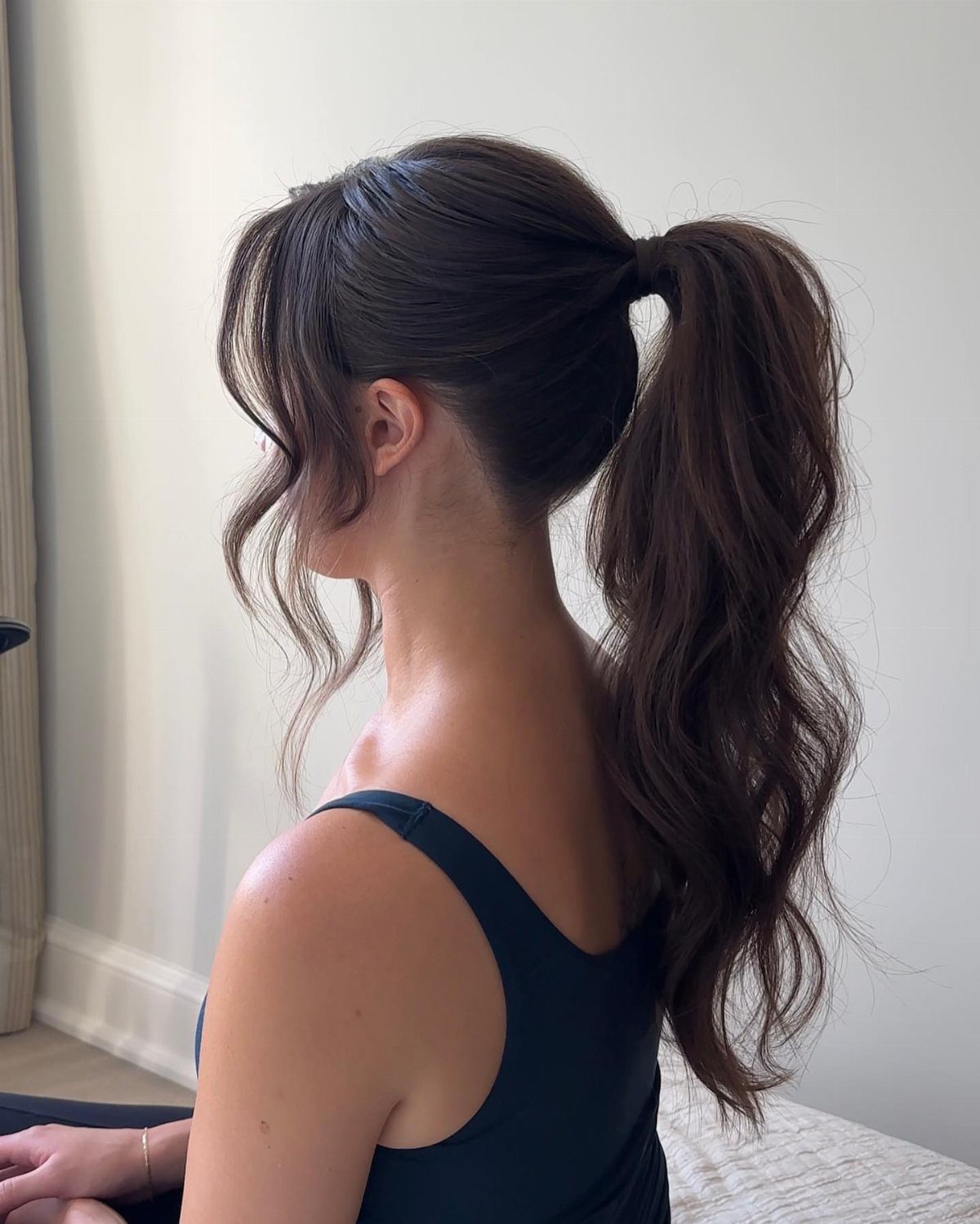 8 Prom Ponytail Hairstyles from Sleek to Curly 6 Woman with a high ponytail featuring voluminous curls and loose face-framing strands.