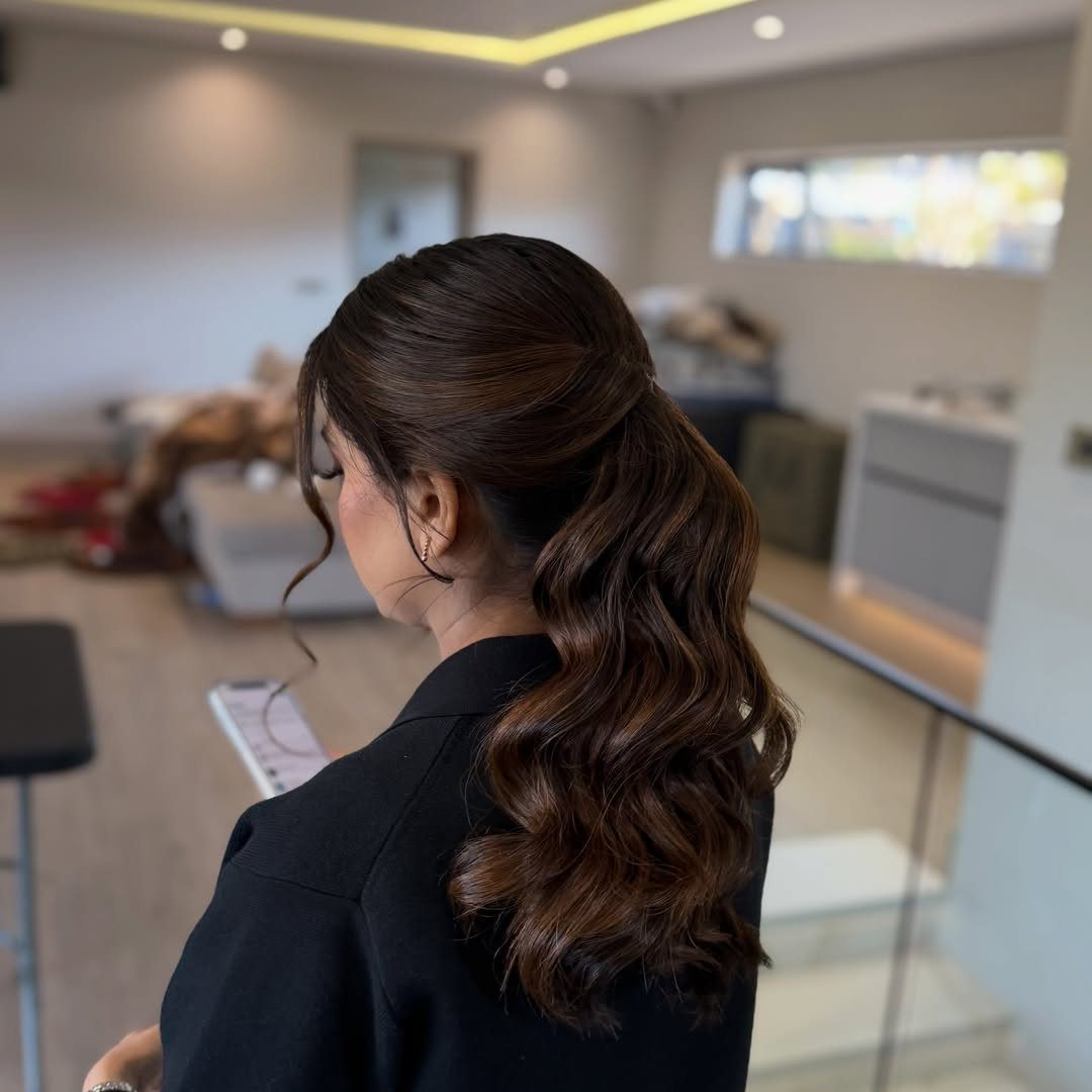 8 Prom Ponytail Hairstyles from Sleek to Curly 8 Woman with brown hair in a low wavy ponytail wearing a black blazer