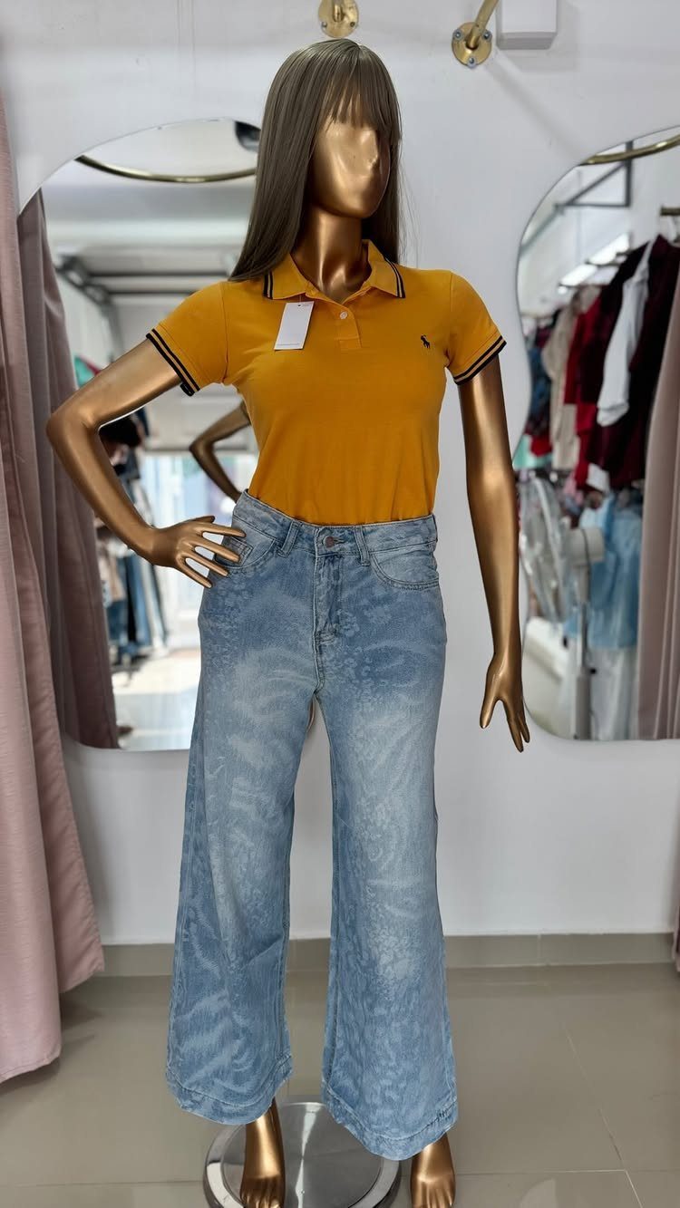 Ralph Lauren Yellow Polo Outfits: 6 Ways to Wear One 1 Mannequin wearing a yellow polo shirt and high-waisted blue wide-leg jeans in a store.