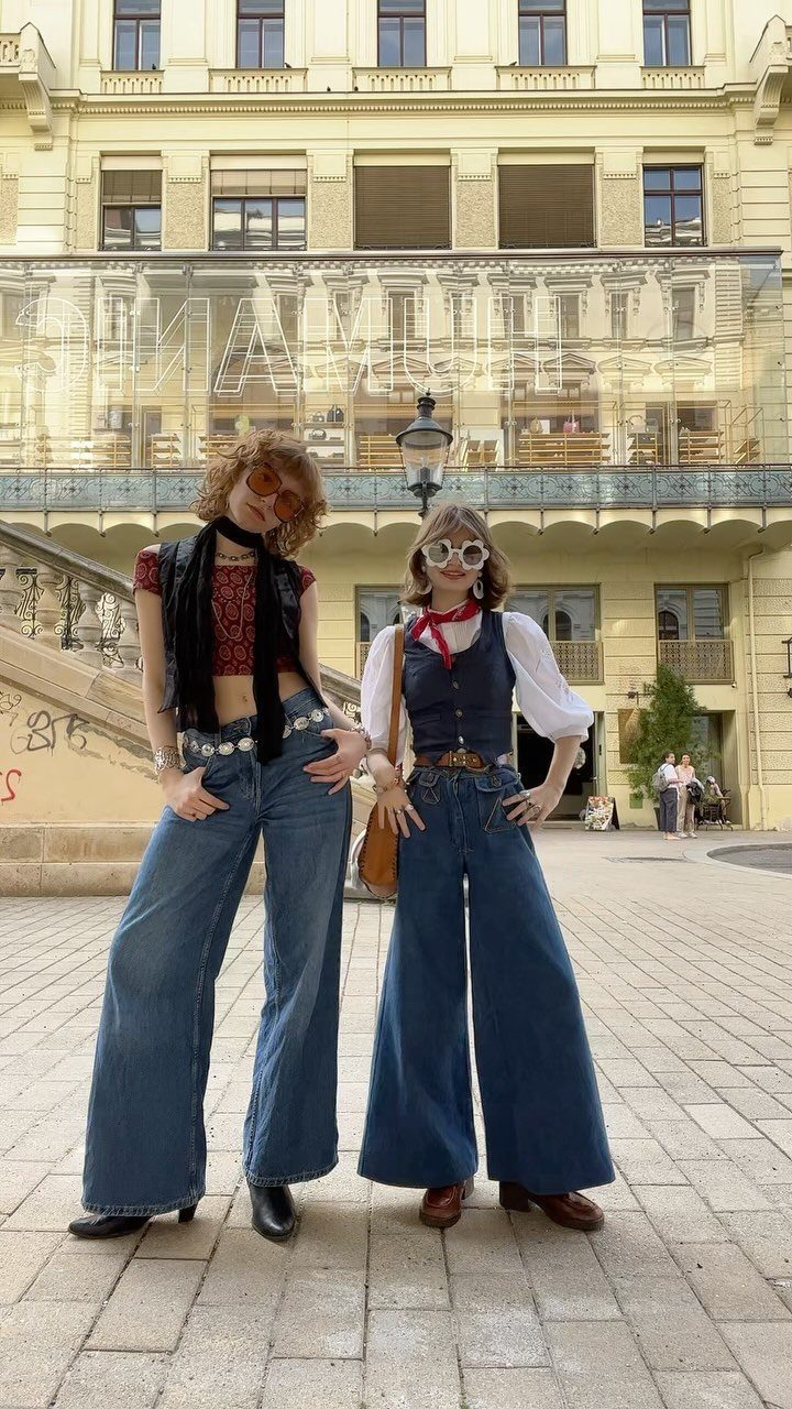 6 Retro Bell Bottoms Ideas for Every Closet and Mood 2 Two women wearing retro blue denim bell bottom jeans in an urban setting