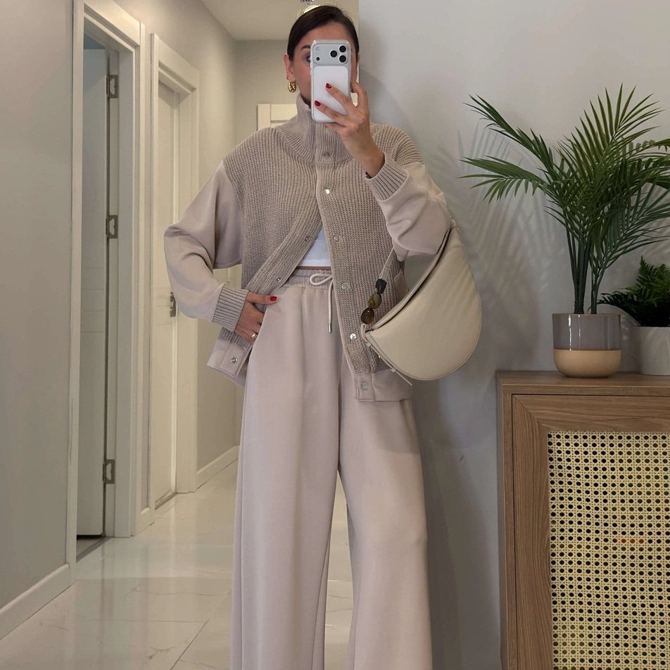 9 Trending Outfit Ideas for Women to Wear Right Now 3 Woman wearing a beige knit cardigan set with wide-leg trousers and cream bag.
