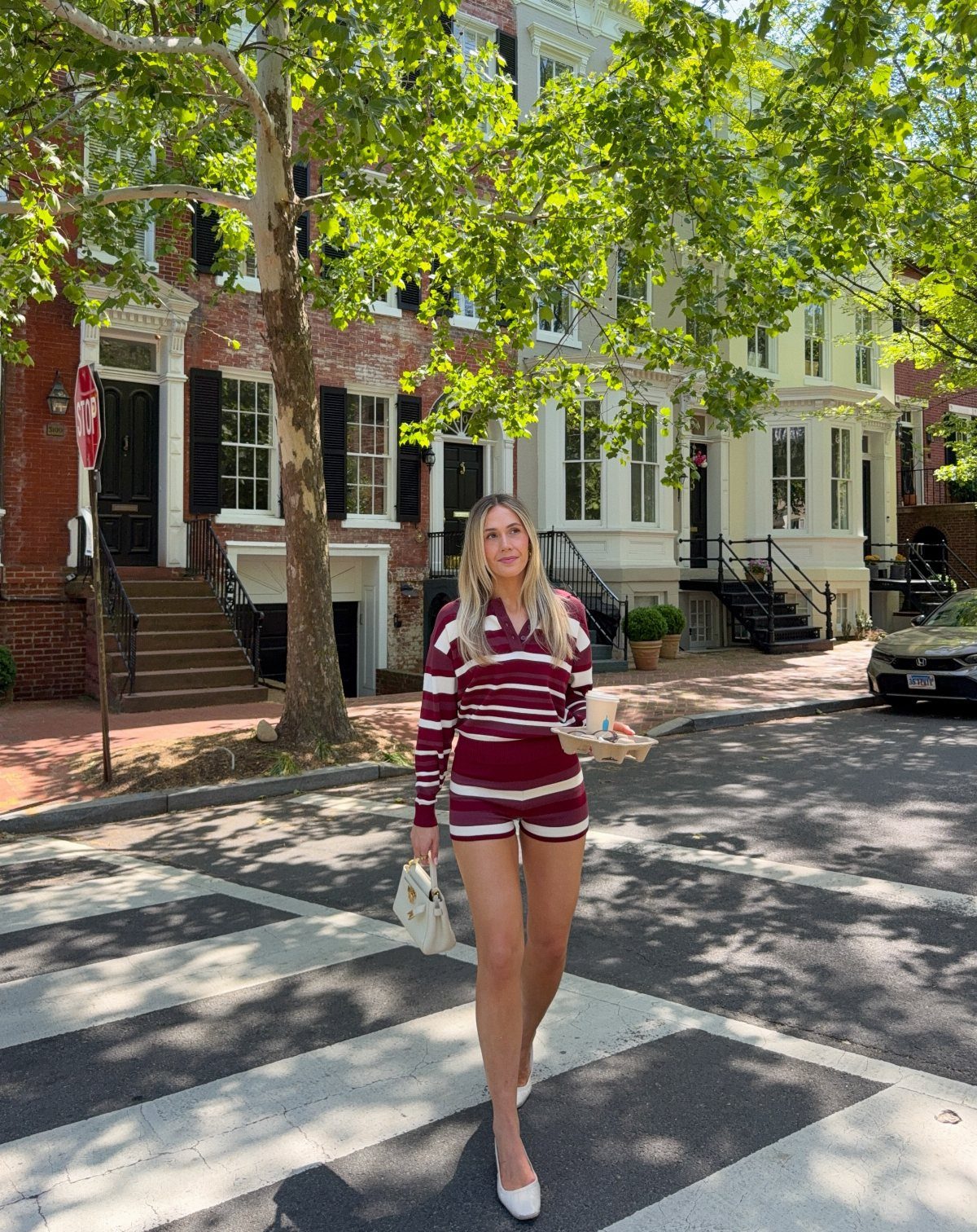 9 Trending Outfit Ideas for Women to Wear Right Now 5 Woman in maroon and white striped matching set standing on a city street.