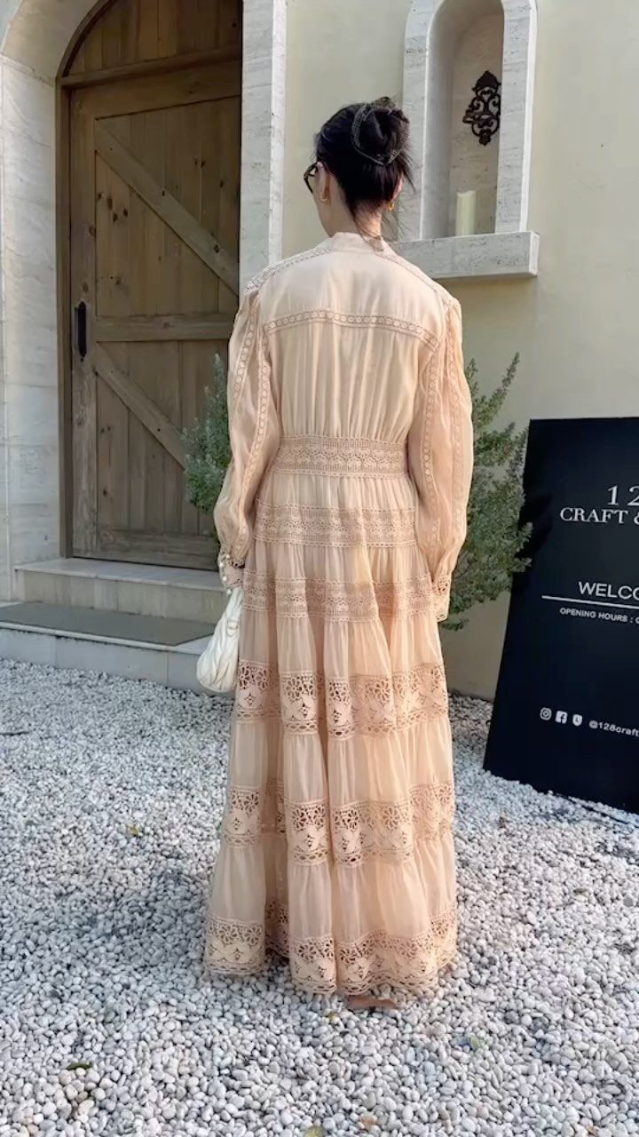 9 Trending Outfit Ideas for Women to Wear Right Now 9 Woman from behind wearing a peach lace maxi dress on white gravel path