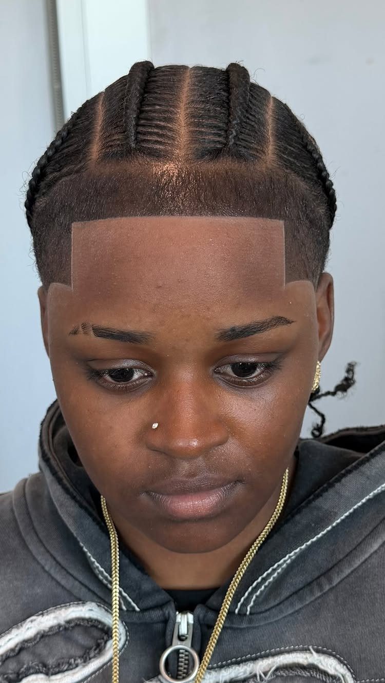 Man with braided cornrows and a sharp line-up fade wearing a grey hoodie