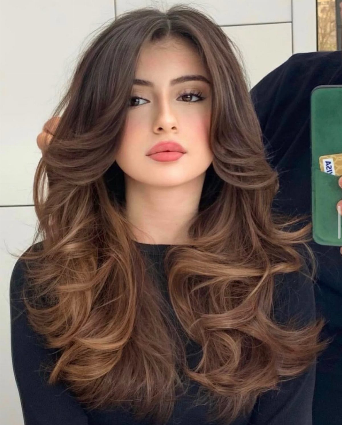 Wavy Hair Styles for Women: 12 Cuts and Looks to Try 9 Woman with long brown hair styled in voluminous, bouncy waves and a center part.