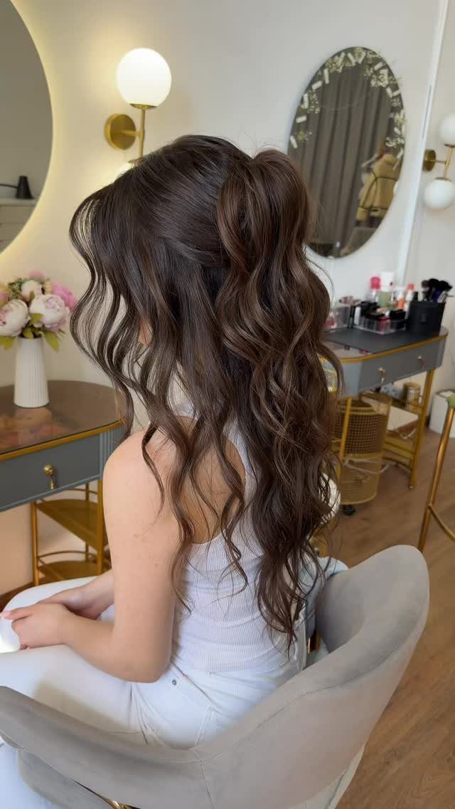 Wavy Hair Styles for Women: 12 Cuts and Looks to Try 7 Woman with long wavy brown hair in a half-up half-down hairstyle in salon