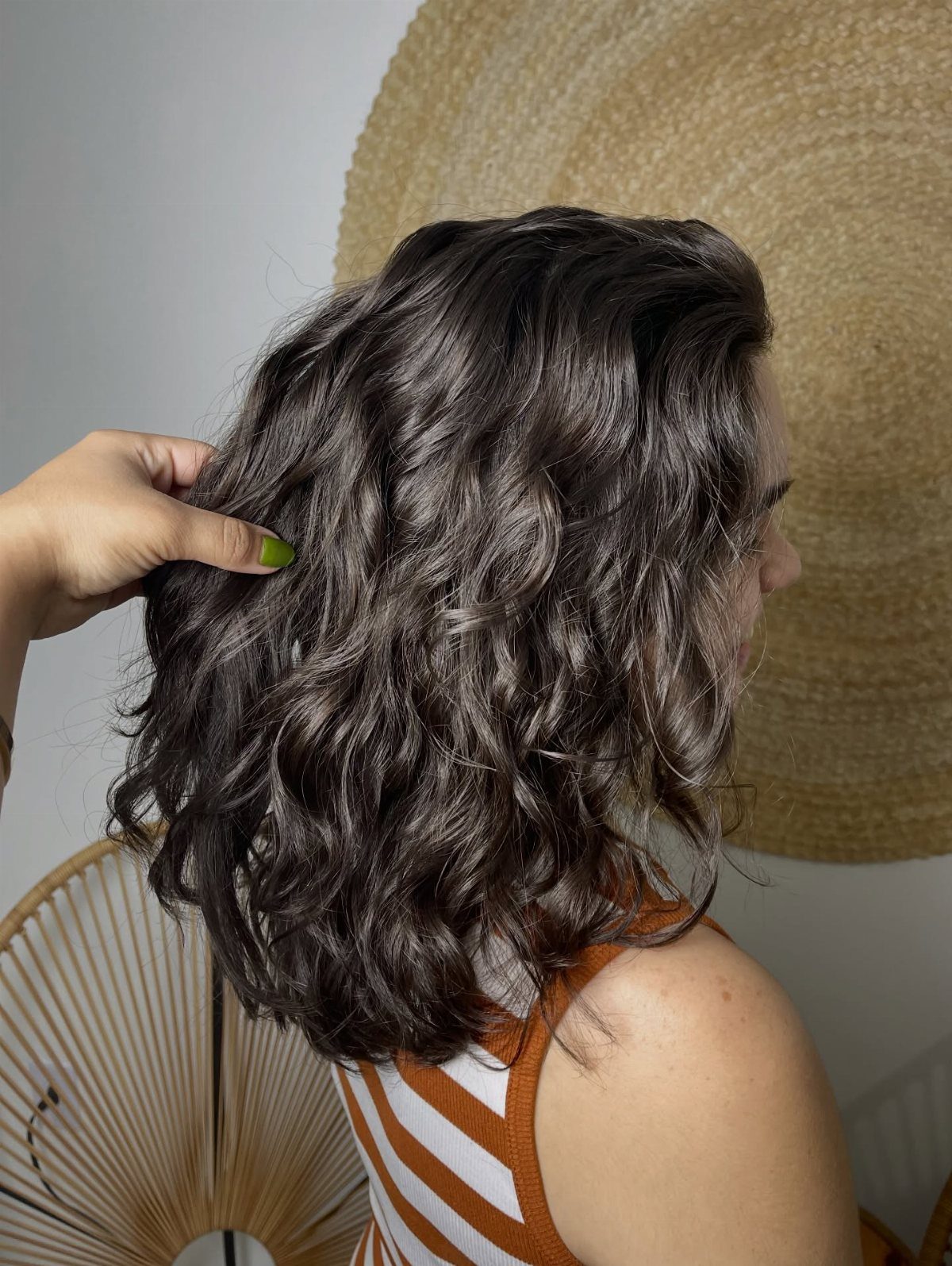 Wavy Hair Styles for Women: 12 Cuts and Looks to Try 10 Woman with a layered lob and wavy brown hair seen from the side.