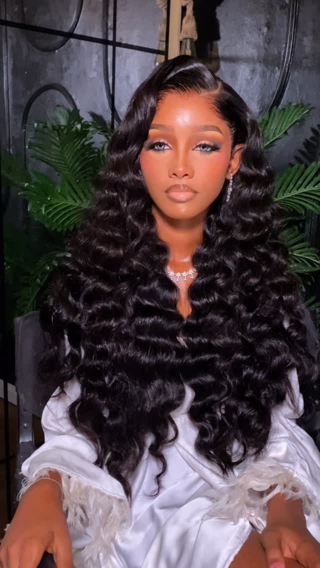 Wavy Hair Styles for Women: 12 Cuts and Looks to Try 5 Woman with long dark wavy hair styled in a side part wearing white satin.