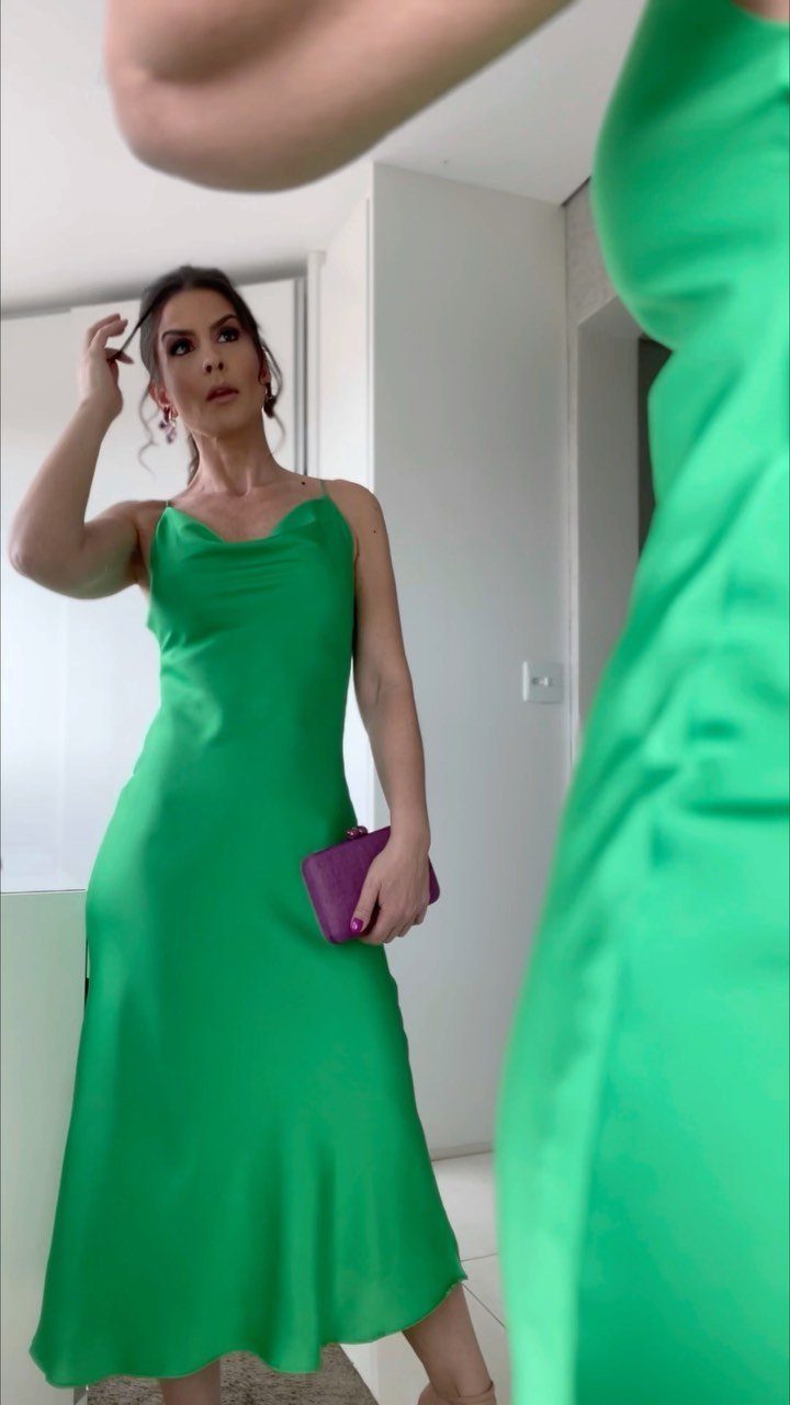 10 Wedding After Party Outfit Ideas for Guests 10 Woman in a bright green silky slip dress holding a purple clutch bag.