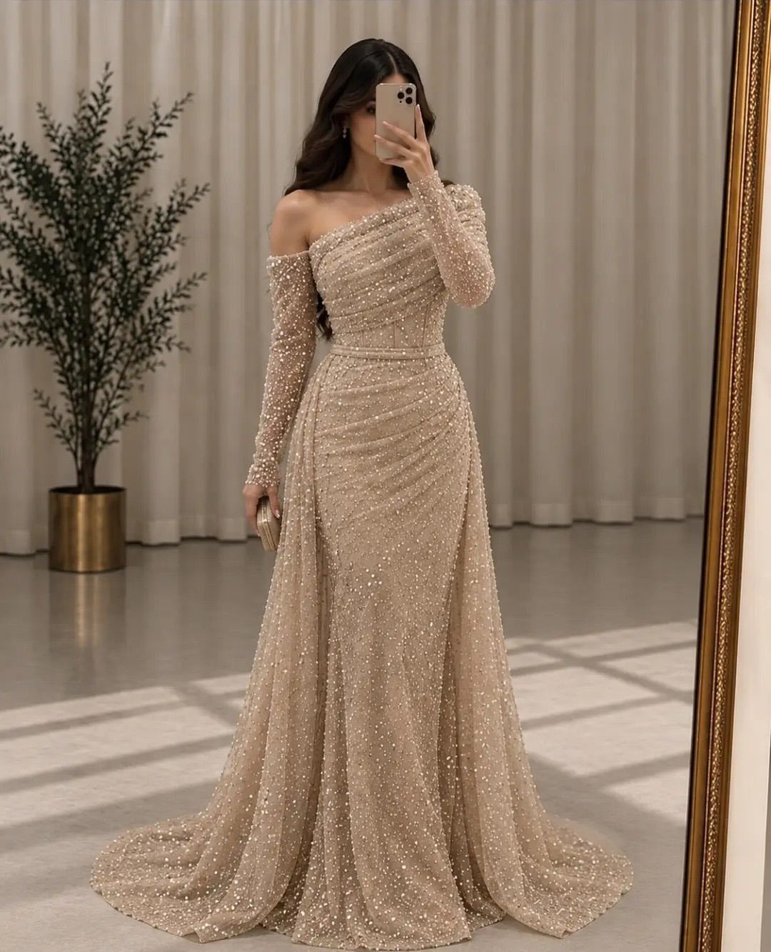 10 Wedding After Party Outfit Ideas for Guests 1 Woman in a shimmering gold sequin floor-length gown taking a mirror selfie.